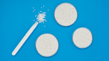 Chemical test tube and round bowls with white polymer granules