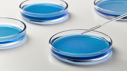 Closeup of a glass dropper with a drop of liquid