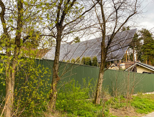 Solar panels mounted on the roof of a large house.