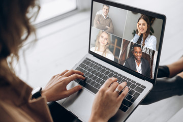 Fototapeta na wymiar Online business meeting. Business team working from home in a video conference. .The girl communicates via video call communication using laptop with her business colleagues about the future strategy