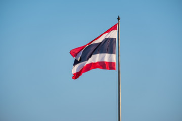 Flag of Thailand with a blue sky backdrop