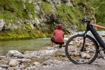 Fototapeta na wymiar Man cyclist and bicycle on the river bank