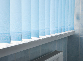 Window blue cotton blinds, vertical louvers, swings is a good window covering in offices.