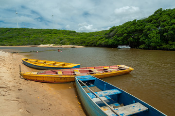 Fototapeta na wymiar Guaju river, Sagi beach, Baia Formosa, near Natal and Pipa beach, Rio Grande do Norte, Brazil on April 19, 2015. Colorful boats and tourists