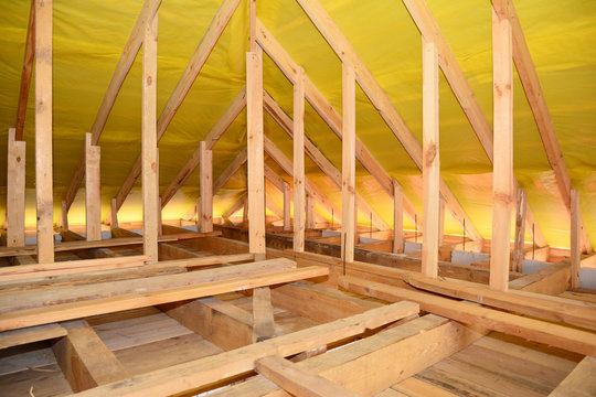 Roofing construction: framing the roof with trusses, braces, roof beams and covering the roof with a vapor barrier, damp proof membrane to prevent moisture from getting inside the house.