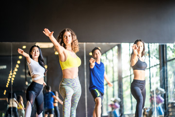 Group of multi-ethnic sport man and women practice the warrior pose in yoga class in studio gym,...
