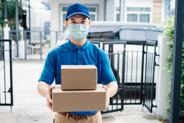 Asian Delivery man wearing mask send a package carton on front receiver shipping deliver social...