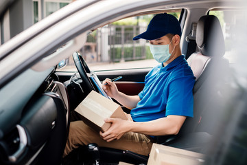 Obraz premium Asian Delivery man wearing mask picking up the package and checking to front home receiver shipping deliver cargo social distancing, Many parcel in car while the virus is spreading quarantine.