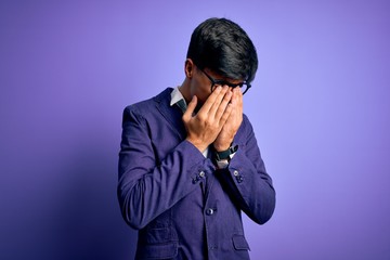 Young handsome business man wearing jacket and glasses over isolated purple background rubbing eyes for fatigue and headache, sleepy and tired expression. Vision problem
