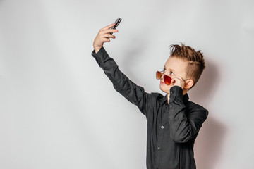 a fashionable guy in sunglasses and a black shirt with a cool hairstyle looks at the phone and...