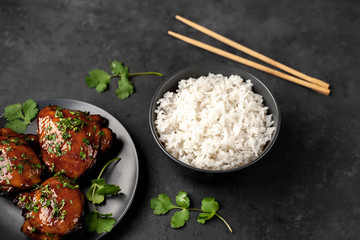 grilled sweet chicken thighs and  cooked rice on a stone background. Asian food
