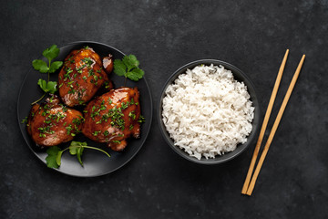 grilled sweet chicken thighs and  cooked rice on a stone background. Asian food