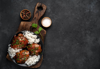 grilled sweet chicken thighs and  cooked rice on a stone background 
with copy space for your text. Asian food