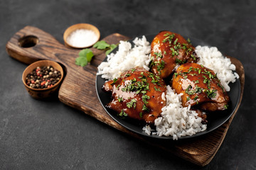 grilled sweet chicken thighs and  cooked rice on a stone background 
with copy space for your text. Asian food