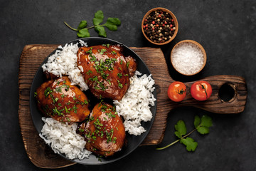 grilled sweet chicken thighs and  cooked rice on a stone background 
with copy space for your text. Asian food