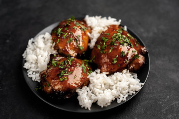 grilled sweet chicken thighs and  cooked rice on a stone background 
 Asian food