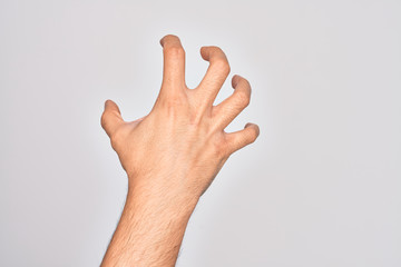 Hand of caucasian young man showing fingers over isolated white background grasping aggressive and scary with fingers, violence and frustration