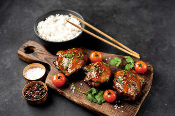 grilled sweet chicken thighs and  cooked rice on a stone background 
 Asian food