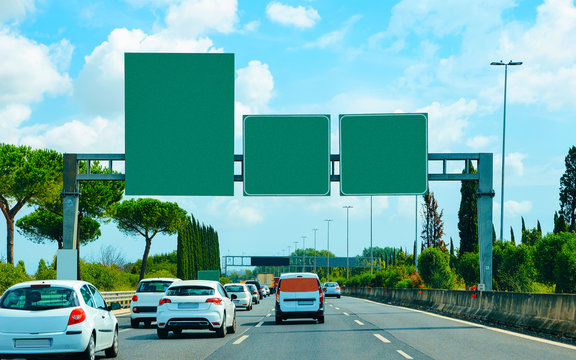 Cars and empty green traffic signs on road in Italy reflex