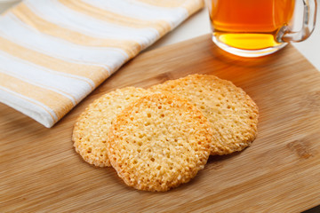 Sesame cookies on the table with cup of black tea on background served at sunny morning