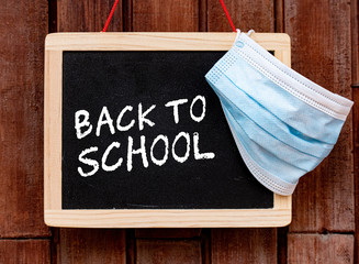 Coronavirus protection back to school blackboard with text and protection medical mask
