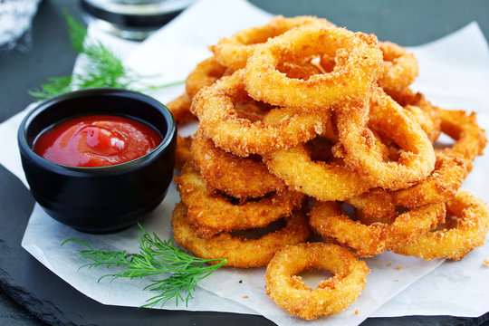 Homemade crunchy fried onion rings with tomato sauce