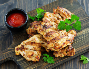Grilled chicken fillet with tomato sauce and greens.