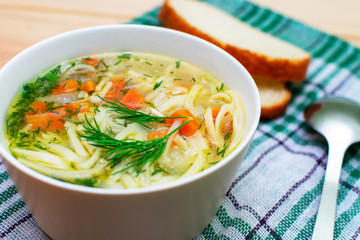 bowl of clear chicken soup with noodle and vegetables