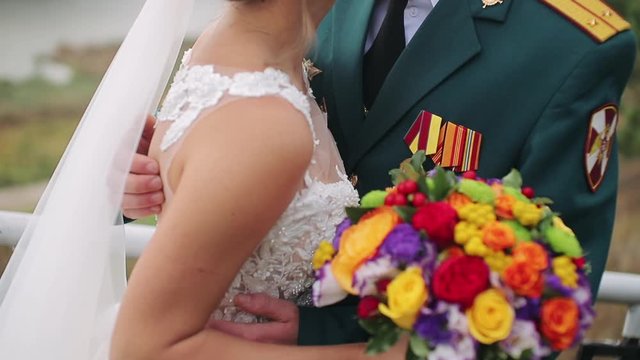 man holding woman around waist. The groom strokes the bride at the waist with his hands close-up