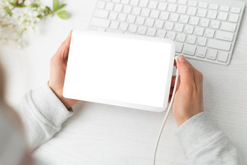 Obraz premium Digital tablet with a blank screen in the hands of a girl. Place for text.