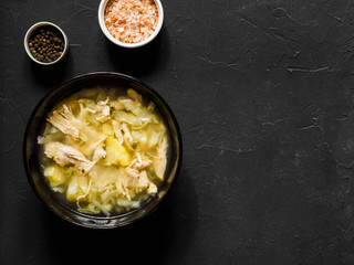 Vegetable chicken soup with cabbage and potatoes in a white black on a dark table. Fresh healthy...
