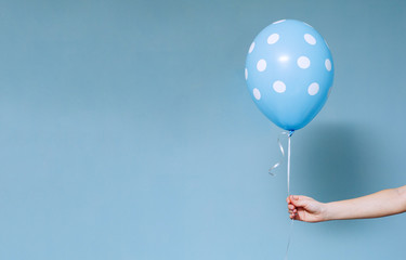stylish birthday party or holidays with balloons close up. Hand  holding blue  balloon isolated on...