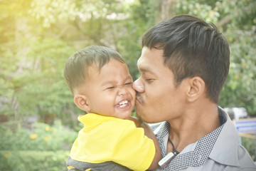 Happy kid when his father hugged and kissed in the park.