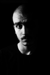 Portrait of a guy with moustache staring intensively into the camera