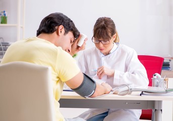 Obraz premium Young doctor checking patients blood pressure