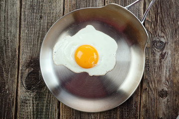 Eggs from one egg on a steel pan on a wooden background