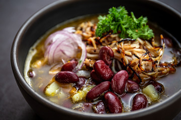 Bean soup with smoked pork, potatoes, herbs, onion