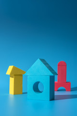 Stay at Home concept, work at home in quarantine, toy colored houses on a blue background, hard light