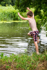 boy jumping into a river