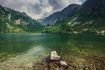 Amazing view of mountains and  Poprad Lake (Popradske pleso) in High Tatras National Park. Slovakia. Europe. Mountain hiking. Concept of travel lifestyle, harmony with nature. Nature background.