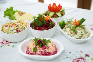 Diet salad with beets . Capital salad . Potato salad . coleslaw salad . set with different salads . Salad ham, orange pepper, mushrooms, pickles, white sauce, on a white bowl.