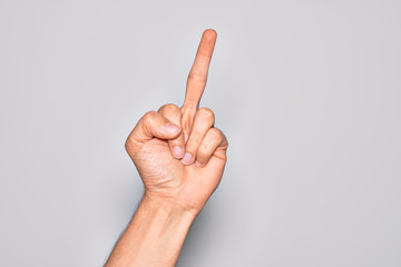 Hand of caucasian young man showing fingers over isolated white background showing provocative and rude gesture doing fuck you symbol with middle finger