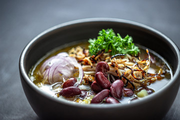 Bean soup with smoked pork, potatoes, herbs, onion