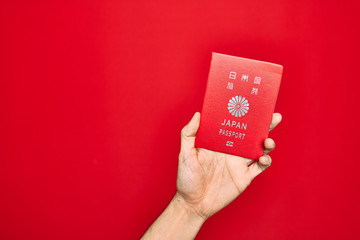 Beautiful hand of man holding italia italian passport identification over isolated red background