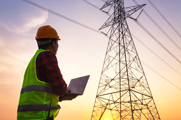 Asian Manager Engineering in standard safety uniform working inspect the electricity high voltage pole.