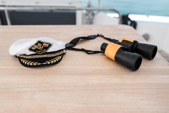 Close-up: captain's hat and binoculars on a yacht. Accessories and paraphernalia for sea cruises