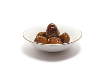 A group of sukkari dates (kurma sukari) on a small plates isolated on white background, perfect for breakfasting during ramadan
