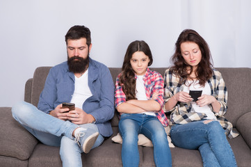 Ignored child. Busy parents surfing internet smartphones. Dad and mom ignoring daughter needs. Bad...