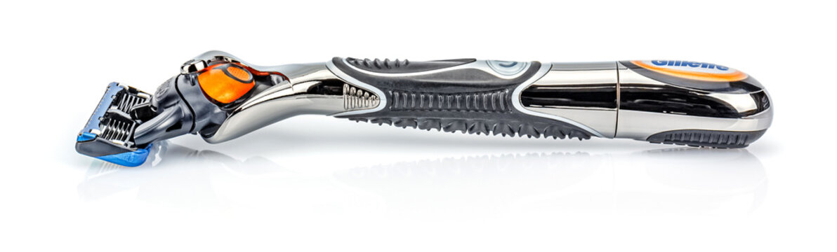 Moscow, Russia - January 23, 2020: Battery handle razor Gillette Fusion Proglide Power Flexball with attached blade lying on white glossy surface with shadow and reflection. Side view