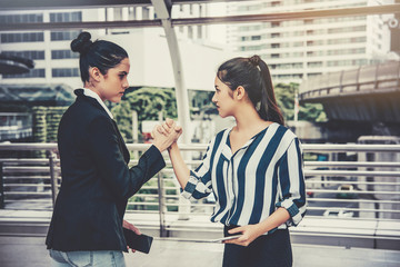 Two businesswaman clash, angry, fight each other